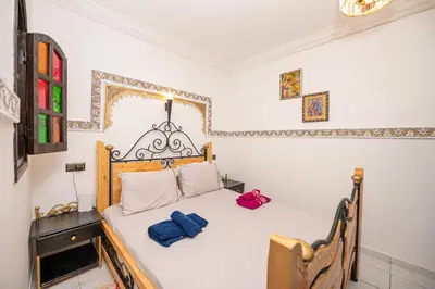 a bedroom with a bed with two blue towels on it at Riad Blue Marrakech 4 Rooms Jacuzzi Terrace and Pool in Marrakech