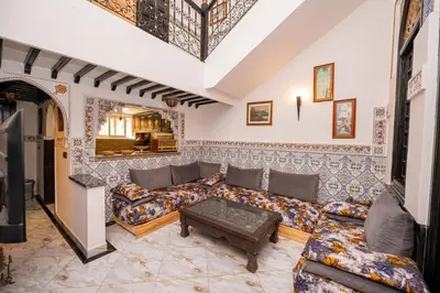 a living room with a couch and a table at Riad Blue Marrakech 4 Rooms Jacuzzi Terrace and Pool in Marrakech