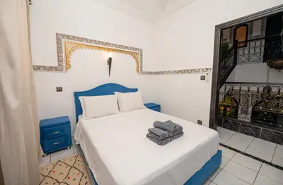 a bedroom with a bed with a blue headboard at Riad Blue Marrakech 4 Rooms Jacuzzi Terrace and Pool in Marrakech