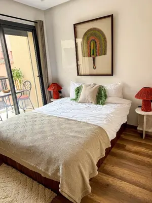 a bedroom with a large bed with a large window at Appartement Haut Standing 2 Chambres avec 2 Terrasses au Centre Gueliz Marrakech in Marrakech