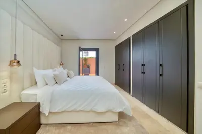 a bedroom with a white bed and a large closet at Plaza Marrakech Comfort Stay in Marrakech