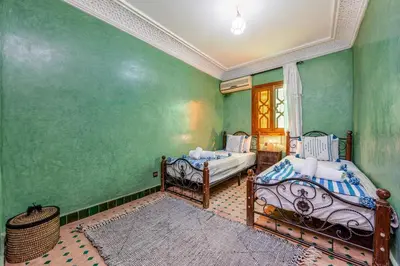 two beds in a room with green walls at Elegant 3-Bedroom Duplex with Pool in Marrakech
