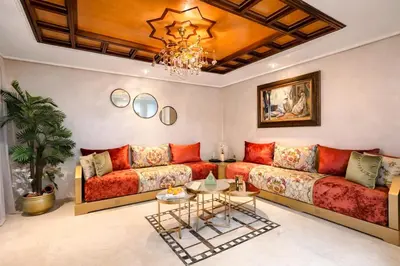 a living room with red couches and a chandelier at Marrakech Guéliz Piscine & Terrasses Ensoleillées in Marrakech