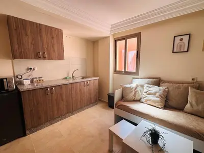 a small living room with a couch and a kitchen at Suite Amethyste - Majorelle in Marrakech