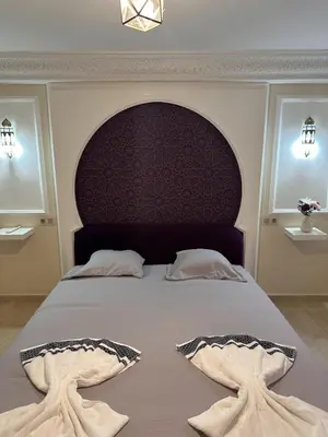 a bedroom with a large bed with two towels on it at Suite Amethyste - Majorelle in Marrakech