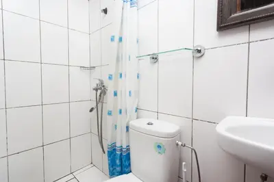 a bathroom with a shower and a toilet and a sink at Hotel Atlas in Marrakech