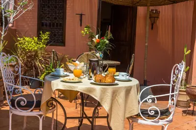 an outdoor table with food and orange juice on it at Hotel Atlas in Marrakech