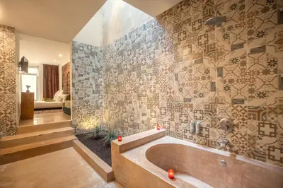 a bathroom with a tub and a stone wall at Ryad Marrakech in Marrakech