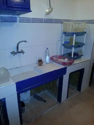 a kitchen counter with a sink and a water bottle on it at Riad Dar Kader chambre bleue in Marrakech