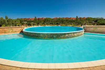 a large swimming pool with blue water at Oliva Hotel Condominium Marrakech in Marrakech