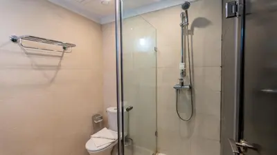 a bathroom with a toilet and a glass shower at Oliva Hotel Condominium Marrakech in Marrakech