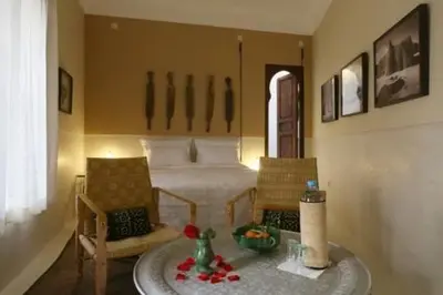 a bedroom with a bed and a table and chairs at Riad Dar Ayur in Marrakech