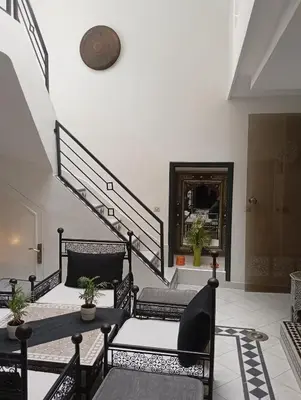 a room with a staircase with chairs and a table at Ryad Ayad in Marrakech