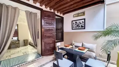 a room with a table and chairs and a door at Riad Argan in Marrakech