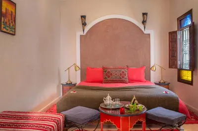 a bedroom with a large bed with red pillows at Riad El Walida in Marrakech