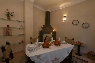 a dining room with a table and a fireplace at Riad El Walida in Marrakech