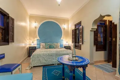 a bedroom with a bed and a table in a room at Riad El Walida in Marrakech