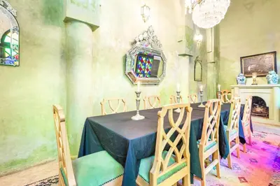 a dining room with a table with chairs and a mirror at Riad Boustane & SPA in Marrakech