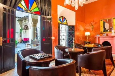 a room with chairs and tables and stained glass windows at Riad Boustane & SPA in Marrakech