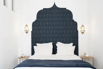 a bedroom with a black headboard and a bed with white pillows at Riad Sashema in Marrakech