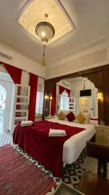 a large bedroom with a large bed with red sheets at Riad Morocco Sky in Marrakech
