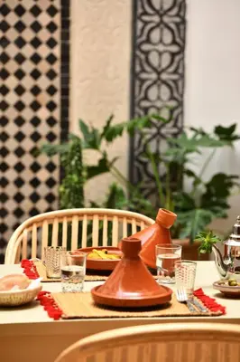 a table with a tea kettle and glasses on it at Riad Lamzia in Marrakech