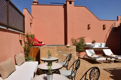 an outdoor patio with tables and chairs at Riad Lamzia in Marrakech