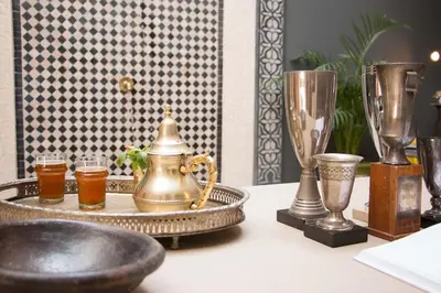 a table topped with trophies and a tray with drinks at Riad Lamzia in Marrakech