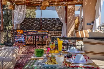 a table with plates of food on a balcony at Riad Sun of Kech in Marrakech