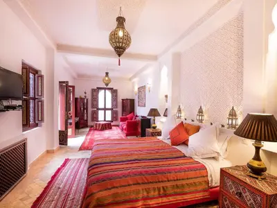 a bedroom with a bed and a living room at Riad Passali in Marrakech