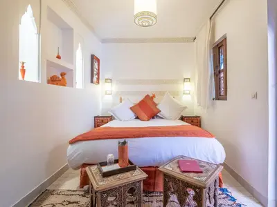 a bedroom with a large bed and a table at Riad Passali in Marrakech