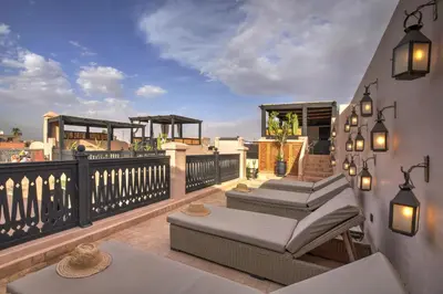 a balcony with several chairs and tables on a patio at Riad Bijoux Marrakech in Marrakech