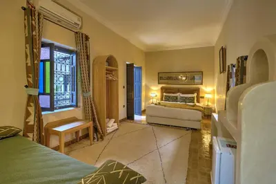 a bedroom with two beds and a window at Riad Bijoux Marrakech in Marrakech