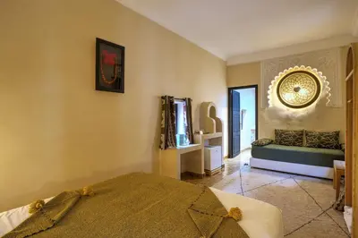 a bedroom with a bed and a mirror on the wall at Riad Bijoux Marrakech in Marrakech