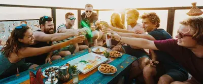 a group of people sitting around a table with drinks at The Madrassa Hostel in Marrakech