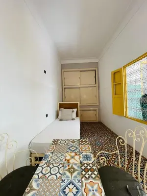 a small bedroom with a bed and a window at The Madrassa Hostel in Marrakech
