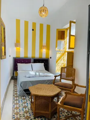 a bedroom with a bed and a chair and a table at The Madrassa Hostel in Marrakech