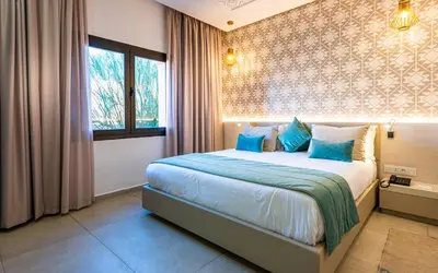 a bedroom with a large bed with blue pillows at TUI BLUE Medina Gardens - Adults Only - All Inclusive in Marrakech