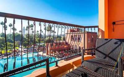 a balcony with a view of a pool and palm trees at TUI BLUE Medina Gardens - Adults Only - All Inclusive in Marrakech