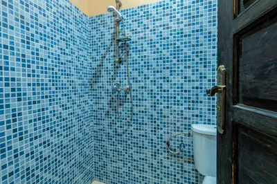 a blue tiled bathroom with a shower with a toilet at Riad Haj Thami in Marrakech