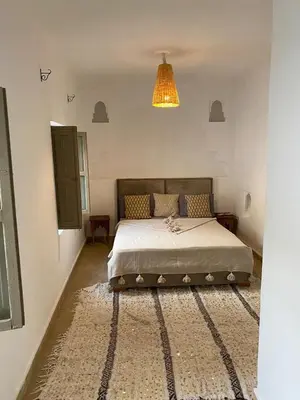 a bedroom with a bed and a chandelier at Private house Riad Arlette exclusive in Marrakech