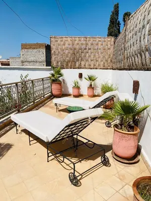 a patio with two tables and potted plants on a balcony at Private house Riad Arlette exclusive in Marrakech
