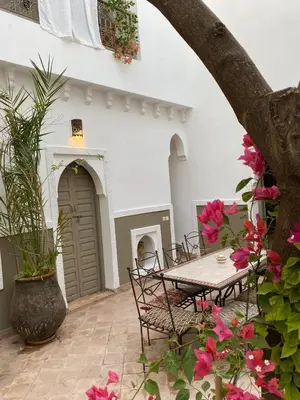 a patio with a table and chairs and flowers at Private house Riad Arlette exclusive in Marrakech