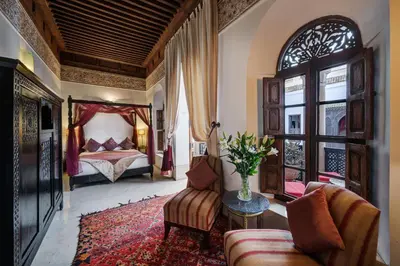 a bedroom with a bed and a couch and a table at Riad Azzar in Marrakech