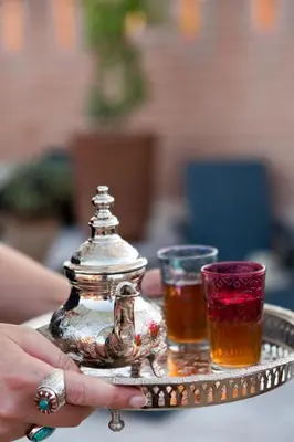 a silver tray with two glasses and a tea pot at Riad Siwan in Marrakech
