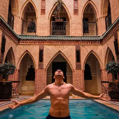 a shirtless man standing in a swimming pool at Riad Challa Hotel & Spa in Marrakech