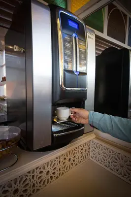 a person is putting a bowl in an oven at Riad Challa Hotel & Spa in Marrakech