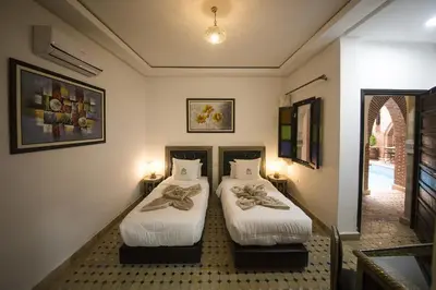 two beds in a room with two lamps at Riad Challa Hotel & Spa in Marrakech