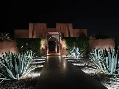 a entrance to a house at night with agave plants at Dar Sofil - Adults Only in Marrakech