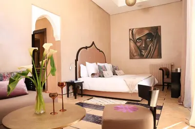 a bedroom with a bed with a painting on the wall at Dar Sofil - Adults Only in Marrakech